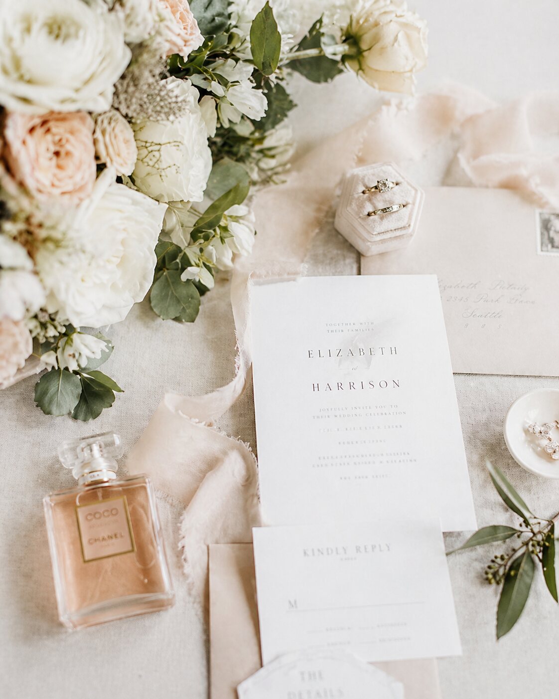 Helle Hochzeitsdetails mit Ringen und Blumen